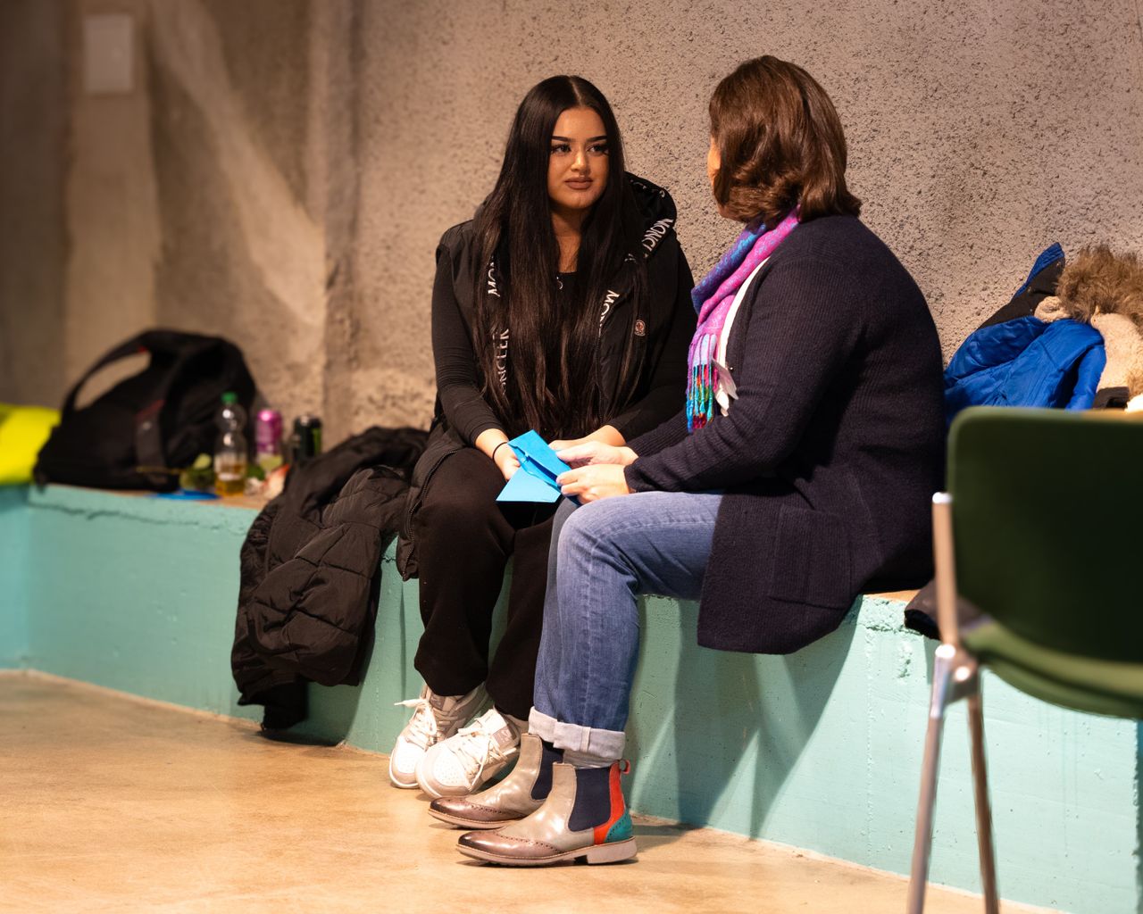 Mentor und Mentee sitzen sich gegenüber und unterhalten sich miteinander.